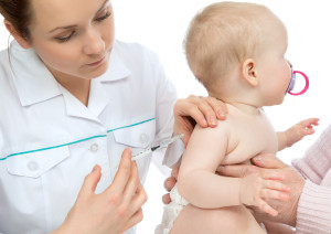 Doctors hand with syringe vaccinating child baby flu injection s